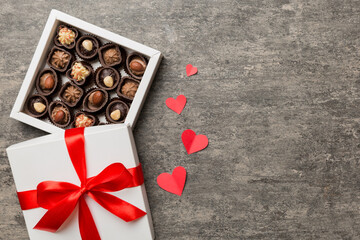 Wall Mural - Delicious chocolate pralines in red box for Valentine's Day. Heart shaped box of chocolates top view with copy space