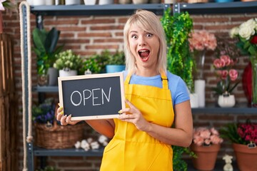 Poster - Young caucasian woman working at florist holding open sign celebrating crazy and amazed for success with open eyes screaming excited.