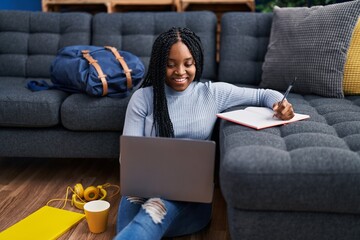 Poster - African american woman student using laptop writing on notebook at street