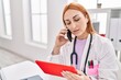 © Krakenimages.com - Young caucasian woman doctor using touchpad talking on smartphone at clinic