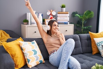 Sticker - Young beautiful hispanic woman listening to music singing song at home