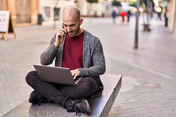 Sticker - Young man talking on the smartphone using laptop at street