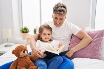 Wall Mural - Father and daughter father and daughter reading book holding teddy bear at bedroom