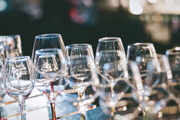 Empty glass for wine over bar shelf, bokeh lights background.