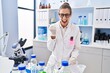 © Krakenimages.com - Young woman working at scientist laboratory celebrating surprised and amazed for success with arms raised and eyes closed