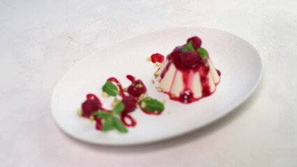 Wall Mural - Smooth on panna cotta with raspberry and mint on white plate, close up, 4k resolution