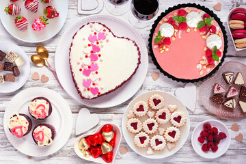 Wall Mural - Valentines Day table scene with a collection of desserts and sweets. Above view on a white wood background. Love and hearts theme.