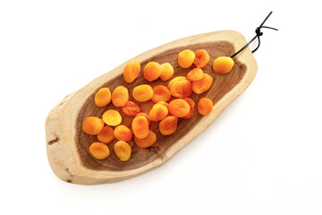 Wall Mural - Dried apricots on a cutting board on a cutting board. Concept of the Jewish holiday Tu Bishvat on white background