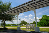 Fototapeta Kawa jest smaczna - Solar panels installed as shade roof over parking lot for parked electric cars for effective generation of clean electricity. Photovoltaic technology integrated in urban infrastructure