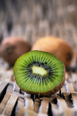 Wall Mural - Ripe juicy kiwi fruit and half kiwi isolated on textural background.