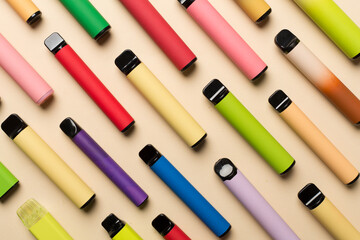 Disposable electronic cigarettes on color background, top view