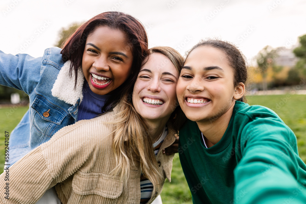 Multi-ethnic group of three young women taking a selfie having fun ...