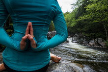 Close Up From Behind Of Woman Practicing Yoga In Eagle Pose On Rock In River, Gorham, New Hampshire, USA