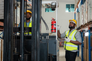 Two African workers working in a warehouse Organize the product system with a forklift truck. transportation industry.