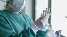 Doctor Putting On Surgical Gloves , Professional Medical Safety And Hygiene For Surgery And Medical Exam.