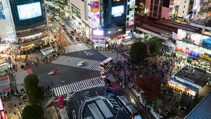 Wall Mural - Night time lapse of car traffic transportation, crowded people walk cross road at Shibuya scramble crossing. Tokyo tourist attraction landmark, Japan tourism, Asia transport or Asian city life concept