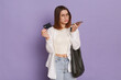 © sementsova321 - Indoor shot of sad upset woman wearing stylish clothing holding bag posing isolated over purple background, holding smart phone and credit card, has no money for paying in shopping mall.