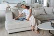 © Iona - Frustrated young woman sitting on cozy couch with books, laptop feels fatigue stares down with unhappy face expression. Overworked hispanic girl feels loneliness after divorce. Troubles, upset people.