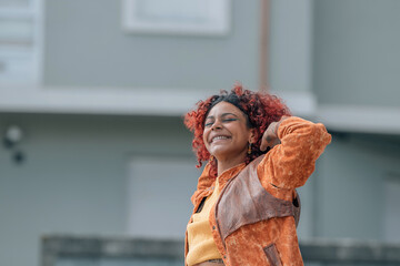 Wall Mural - smiling afro girl in the street outdoors enjoying relaxed