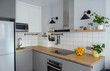 Modern stylish Scandinavian kitchen interior with kitchen accessories. Bright white and grey kitchen with household items in studio apartment
