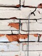 Funky brick wall background with cracked mortar, chipped white paint and bent wire hanger