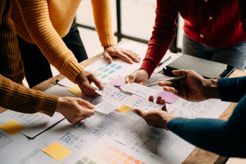 Close up view of UI developer team brainstorming on their project with laptop, smartphone and digital tablet. Creative digital development agency