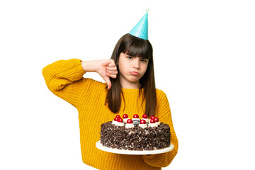 Canvas Print - Little girl holding birthday cake over isolated chroma key background showing thumb down with negative expression