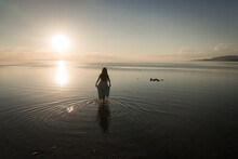 Silhouette Of A Girl In Blue Dress Standing In Salt Lake, Utah, USA, At Sunset