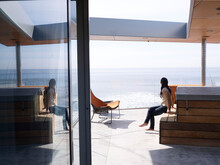 A Lady Sits In A Chair And Watches The Ocean At An Oceanfront Home In La Jolla, California.