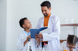 Student workship training with Science teacher show the experiment result of chemistry test with happy, elementary pupils in white gowns study in laboratory using pipette dropping liquid to glass tube