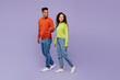 © ViDi Studio - Full body side view young couple two friend family man woman of African American ethnicity wear casual clothes hold hands walk go together point back aside isolated on pastel plain purple background.