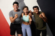 portrait group of young friends or trainers winner gesture after workout in the gym