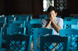 © anut21ng Stock - Portrait of Asian man covering his face with his hands in worried thought. Lonely stress in a room with lots of chairs