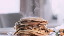 Sweet French And Russian Homemade Thin Pancakes Crepes, Stack Of Fresh Baked Crepes With Raised Steam On Morning Table Breakfast.