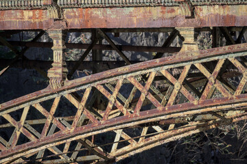 The rusty metal structure of an old bridge. Rusty wrought iron archway.