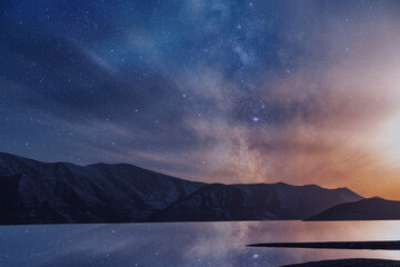 Wall Mural - Beautiful night landscape. Small lake and mountains on the bright milky way galaxy with clouds. Starry  night.