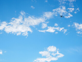 Wall Mural - The passenger airplane is flying far away in the blue sky and white clouds. Aircraft in the air. International passenger air transportation. Background or backdrop