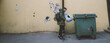 © Anna - A young man throws a cardboard box into a trash can on the street. Eco-friendly waste collection and separation.