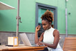 © jorge - Happy woman watching and listening media on laptop in a bar