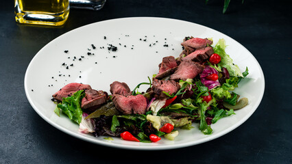 Poster - Fresh salad with beef slices, pickled cucumber, beans, arugula, lettuce and cherry tomatoes.