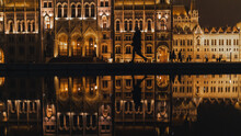 Silhouette Of A Person Walking By The Hungarian Parliament Building With The Reflection In Water