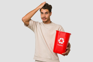 Young caucasian man holding a plastic trash isolated being shocked, she has remembered important meeting.