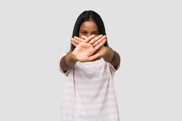 Young Indian woman cut out isolated on white background doing a denial gesture