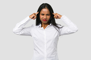 Wall Mural - Young Indian woman cut out isolated on white background focused on a task, keeping forefingers pointing head.