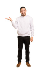 full body adult latin man cut out isolated showing a copy space on a palm and holding another hand o