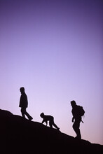 A Family Goes Hiking Together In On Red Rocks During A Family Vacation.