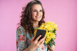 © Alliance - smiling trendy woman using smartphone applications on pink