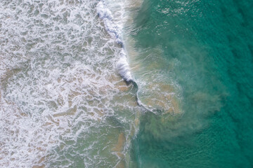 Wall Mural - Aerial view of stunning waves crushing near sand banks in a stunning blue water