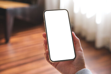 Mockup image of a woman holding mobile phone with blank desktop screen