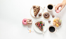 Table With Various Cookies, Donuts, Cakes,  Coffee Cups On White  Background.